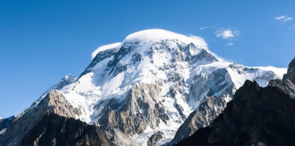 Climbers ascending the West Spur of Broad Peak with K2 visible across the glacier, Karakoram