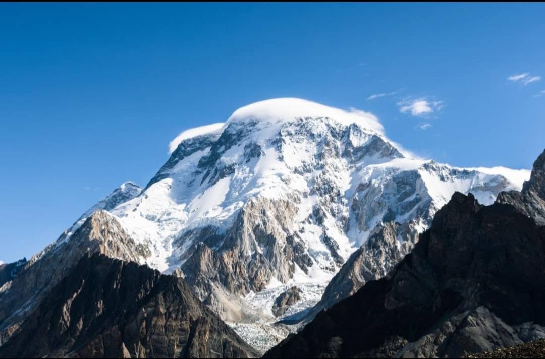 Climbers ascending the West Spur of Broad Peak with K2 visible across the glacier, Karakoram