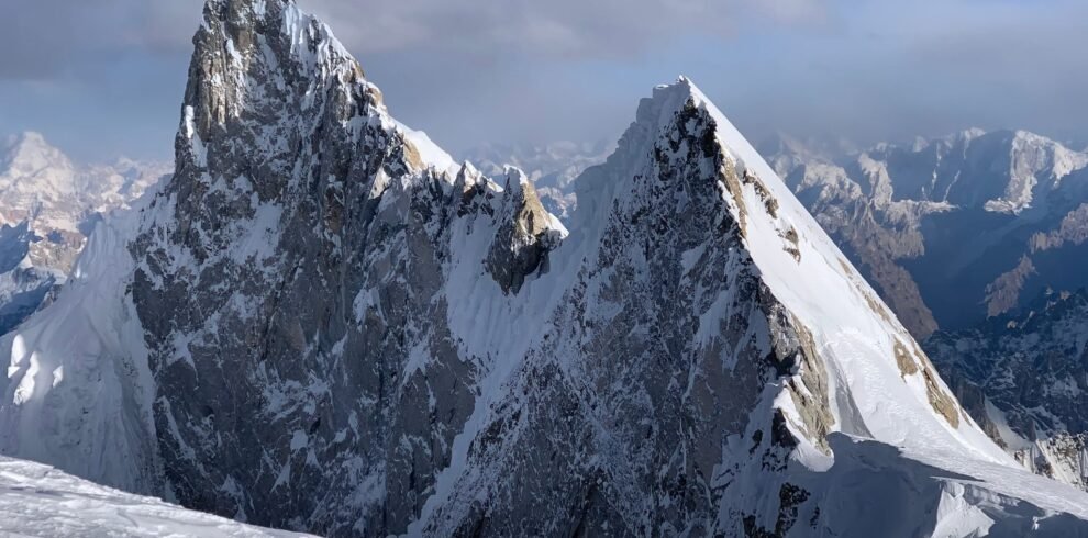 Climbers ascending K6 with the Charakusa Valley and Masherbrum range below, Karakoram